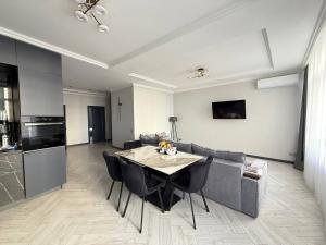 een woonkamer met een tafel en een bank bij Kamanina Luxury Apartment in Odessa