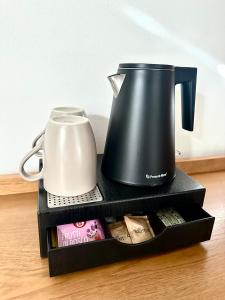 una macchinetta del caffè e un bollitore su una mensola di Hotel Ferrari a Pinzolo