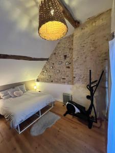 Un dormitorio con una cama y una pared de piedra. en Villa événements Balnéo & Spa, en Villampuy