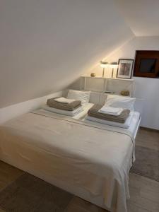 a white bed with towels on top of it at Noel in Vukovar