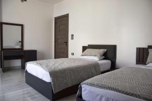 a bedroom with two beds and a mirror and a desk at Quiet Corner Apartment in Luxor +53 photos