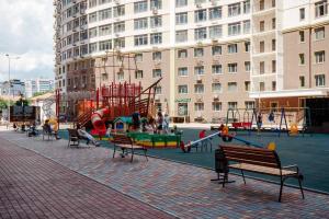 een speeltuin met banken en glijbanen in een stad bij Kamanina Luxury Apartment in Odessa
