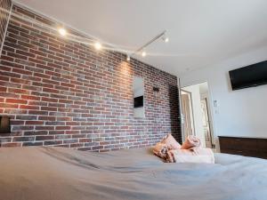 een slaapkamer met een bakstenen muur en een bed bij La Ressource, Claire in Fontguenand