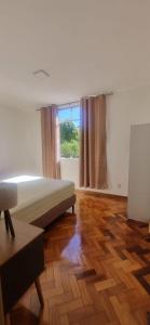 a white room with a bed and a window at O melhor de Terê in Teresópolis