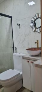 a white bathroom with a toilet and a sink at O melhor de Terê in Teresópolis