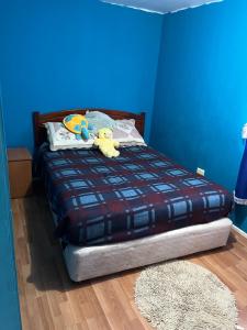 ein blaues Schlafzimmer mit einem Bett mit Stofftieren darauf in der Unterkunft Arriendo Pichilemu in Pichilemu