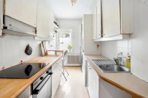 eine Küche mit weißen Schränken und einer Spüle in der Unterkunft Spaceous room in Majorstuen central Oslo by subway in Oslo
