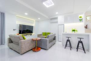 een witte woonkamer met twee stoelen en een toonbank bij KARN E2 House Khaoyai in Mu Si