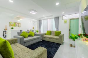 een woonkamer met 2 banken en groene kussens bij KARN E2 House Khaoyai in Mu Si +42 foto's