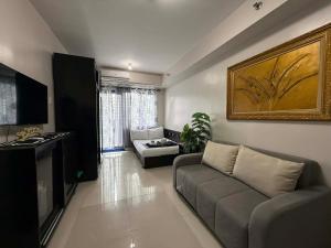 ein Wohnzimmer mit Sofa und Fernseher in der Unterkunft Sea Residences Wonders in Manila