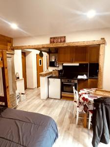 a room with a kitchen with a table and a kitchen at Studio cosy proximité télécabine ski Meribel - Cure thermale in Brides-les-Bains