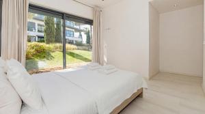 a bedroom with a white bed and a large window at Cavalo Preto Ocean Breeze Apartment in Forte Novo Quarteira in Quarteira +21 photos