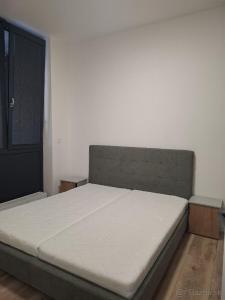 een bed in een slaapkamer met een witte matras bij Apartmán Central Point 1 in Humenné