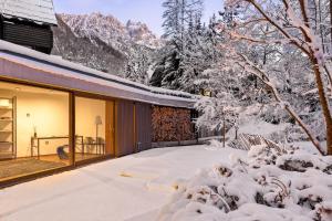 een sneeuwbedekte tuin met een huis bij Villa Jasna in Kranjska Gora