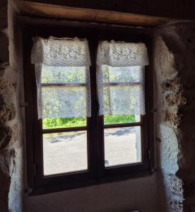 - une fenêtre ouverte avec des rideaux dans la chambre dans l'établissement La maison du bord de l'eau plage de baignade, à Vayrac