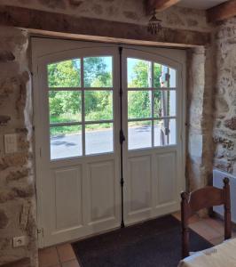 une porte avec deux fenêtres dans une pièce dans l'établissement La maison du bord de l'eau plage de baignade, à Vayrac