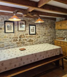 une chambre avec un lit dans un mur de pierre dans l'établissement La maison du bord de l'eau plage de baignade, à Vayrac