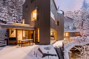 een huis in de winter met sneeuw op de grond bij Villa Jasna in Kranjska Gora