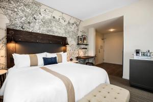 a hotel room with a large bed and a map on the wall at enVision Hotel Worcester Downtown in Worcester