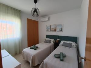 ein Zimmer mit zwei Betten und einem Fenster in der Unterkunft Rincon de Almerimar Palm Beach Golf in Almerimar