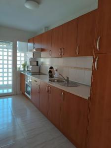 eine Küche mit Holzschränken und einer Spüle in der Unterkunft Rincon de Almerimar Palm Beach Golf in Almerimar