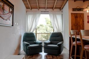 a living room with two chairs and a balcony at Loft Privado- Gran Vista- A 30 mins de Termales in Santa Rosa de Cabal