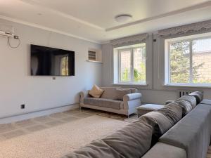 ein Wohnzimmer mit Sofa und Fernseher in der Unterkunft Villa Mountain Medeu in Almaty