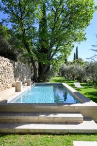 ein Swimmingpool in einem Garten mit Treppe und Bäumen in der Unterkunft Le Hameau des Sources Lourmarin Luberon in Apt