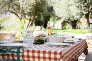 ein Tisch mit kariertem Tischtuch und einer Flasche Wein in der Unterkunft Le Hameau des Sources Lourmarin Luberon in Apt + 47 Fotos