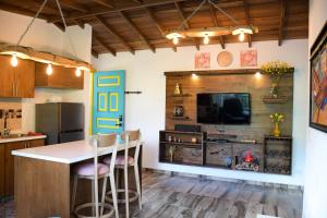 a kitchen with a kitchen island with chairs and a tv at Loft Privado- Gran Vista- A 30 mins de Termales in Santa Rosa de Cabal