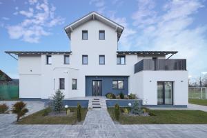 a white house with a black roof at EPIC Vila Brașov, Cristian in Braşov