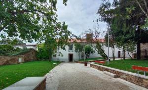a large white house with a yard with a grassy field at Pensión CasaBlanca in Arzúa