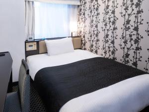 東京にあるアパホテル〈御茶ノ水駅北〉のベッドルーム1室(ベッド1台、黒毛布、窓付)