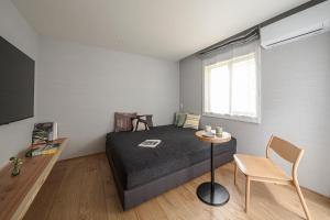 a bedroom with a bed and a table and a window at Shiki - Hakone- in Hakone +101 photos