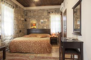 a bedroom with a bed and a stone wall at Hunnap Han in Kucukkuyu