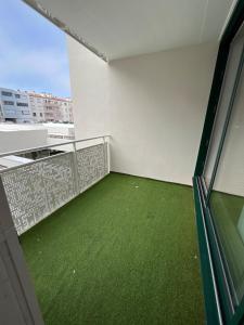 a balcony with green flooring in a building at Hyper centre parking privé in La Roche-sur-Yon