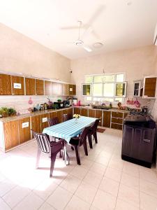 a large kitchen with a table and chairs in it at mandegar guest house in Mawāliḩ
