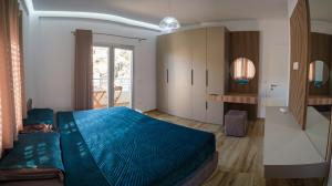 ein Schlafzimmer mit einem blauen Bett in einem Zimmer in der Unterkunft The Grand Villa Babo in Vlorë