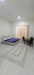 a bedroom with a bed and a table and chairs at mandegar guest house in Mawāliḩ