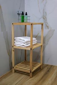 ein Holzregal mit Handtüchern darauf in einem Badezimmer in der Unterkunft The Grand Villa Babo in Vlorë