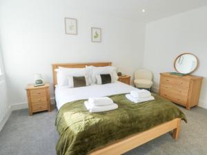 a bedroom with a bed with two towels on it at Glynllifon 4 in Llanallgo