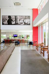 un salon avec un canapé, des tables et des chaises dans l'établissement Iu-á Hotel, à Juazeiro do Norte