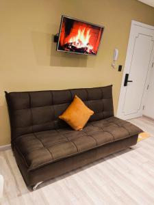 a brown couch with a television on a wall at Holy Home in Cochabamba