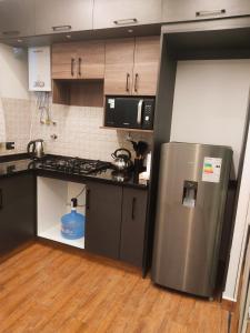a kitchen with a stainless steel refrigerator in a room at Holy Home in Cochabamba