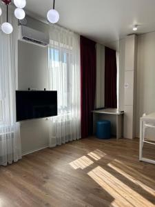 een woonkamer met een flatscreen-tv en gordijnen bij FLAT24 - Red in Zhezdi