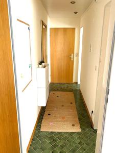 a hallway with a door and a rug on the floor at FeWo Alpsee Hornweg in Immenstadt im Allgäu