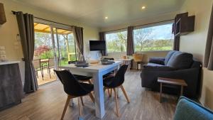 ein Wohnzimmer mit Tisch, Stühlen und Sofa in der Unterkunft Camping 4 étoiles - Parc aquatique - ccbcbhg in Caro