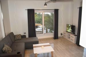 a living room with a couch and a window at Quiet Corner Apartment in Luxor