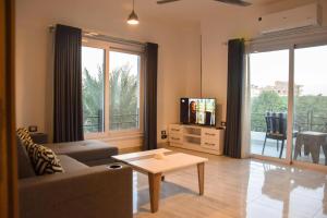 a living room with a couch and a tv and a table at Quiet Corner Apartment in Luxor