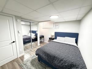 een slaapkamer met een bed en een spiegel bij 2-Bed Cozy Nest in Winnipeg